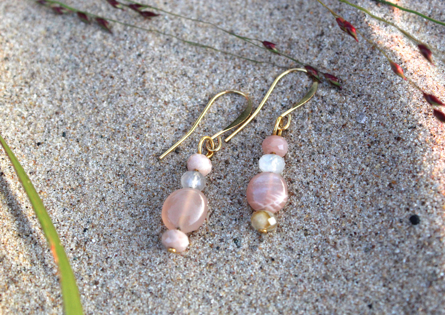 Peach and grey moonstone gold drop earrings styled outdoors