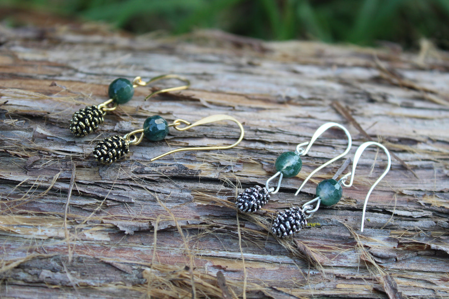 Moss agate gold pine cone drop earrings styled on wood
