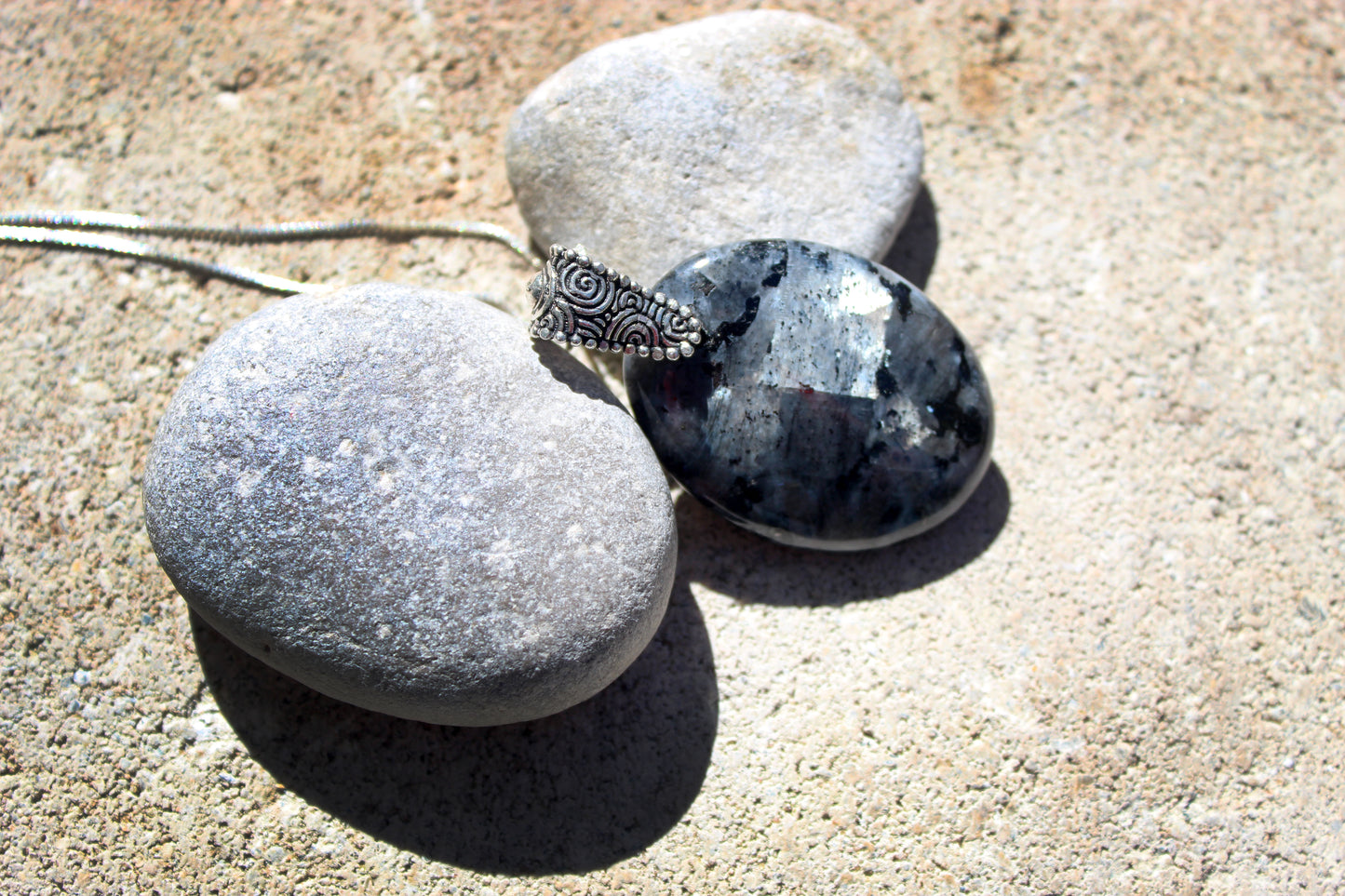 Black labradorite pendant necklace styled with natural stones