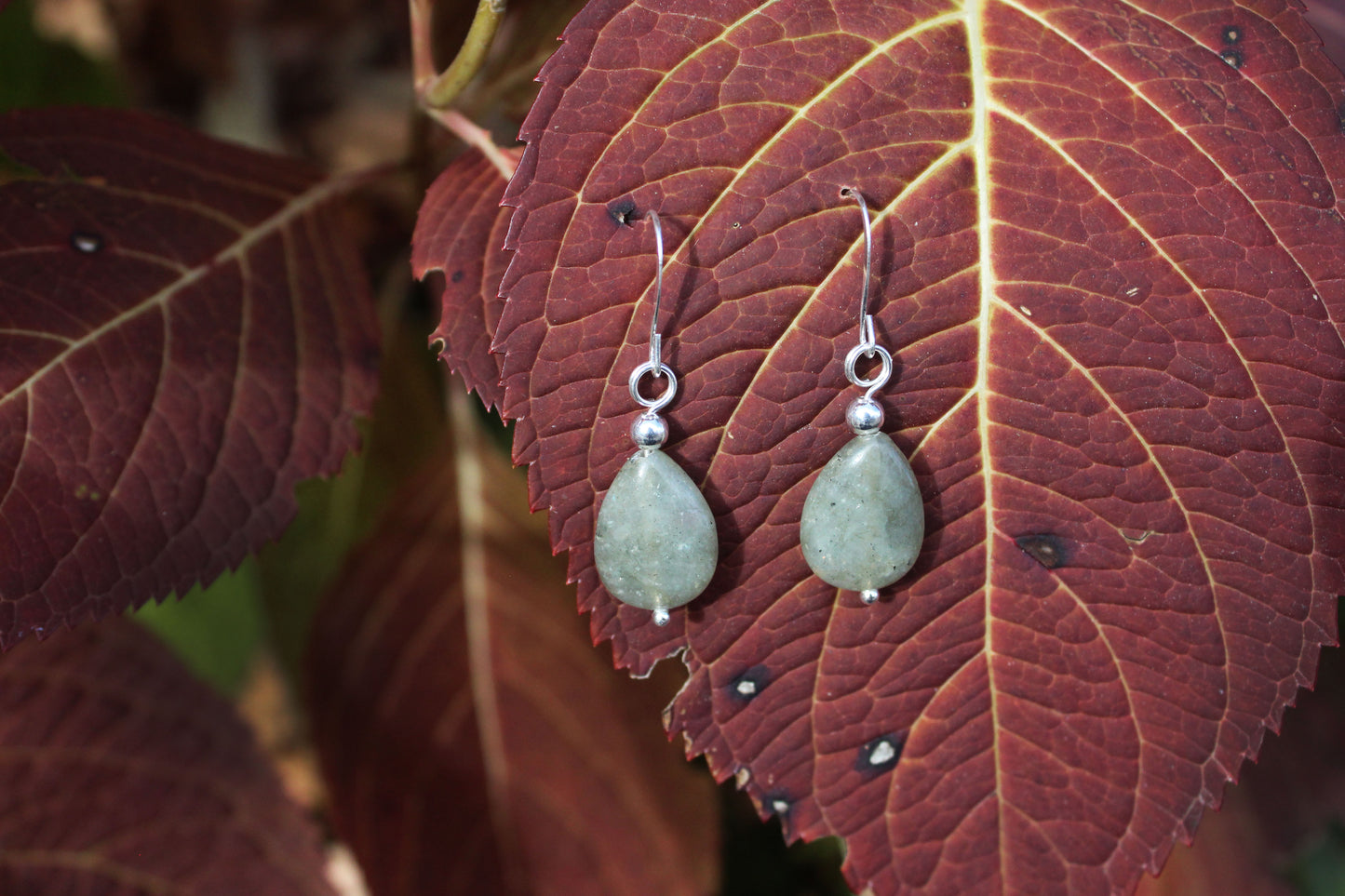 Labradorite silver drop earrings styled on leaf