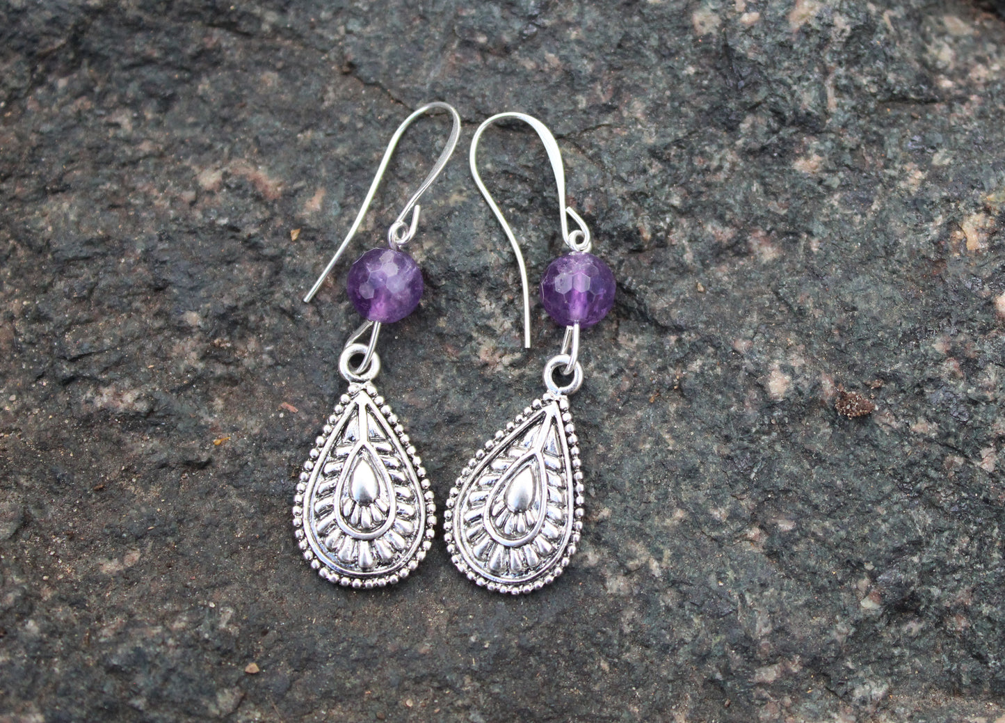 Amethyst teardrop sterling silver earrings on stone surface