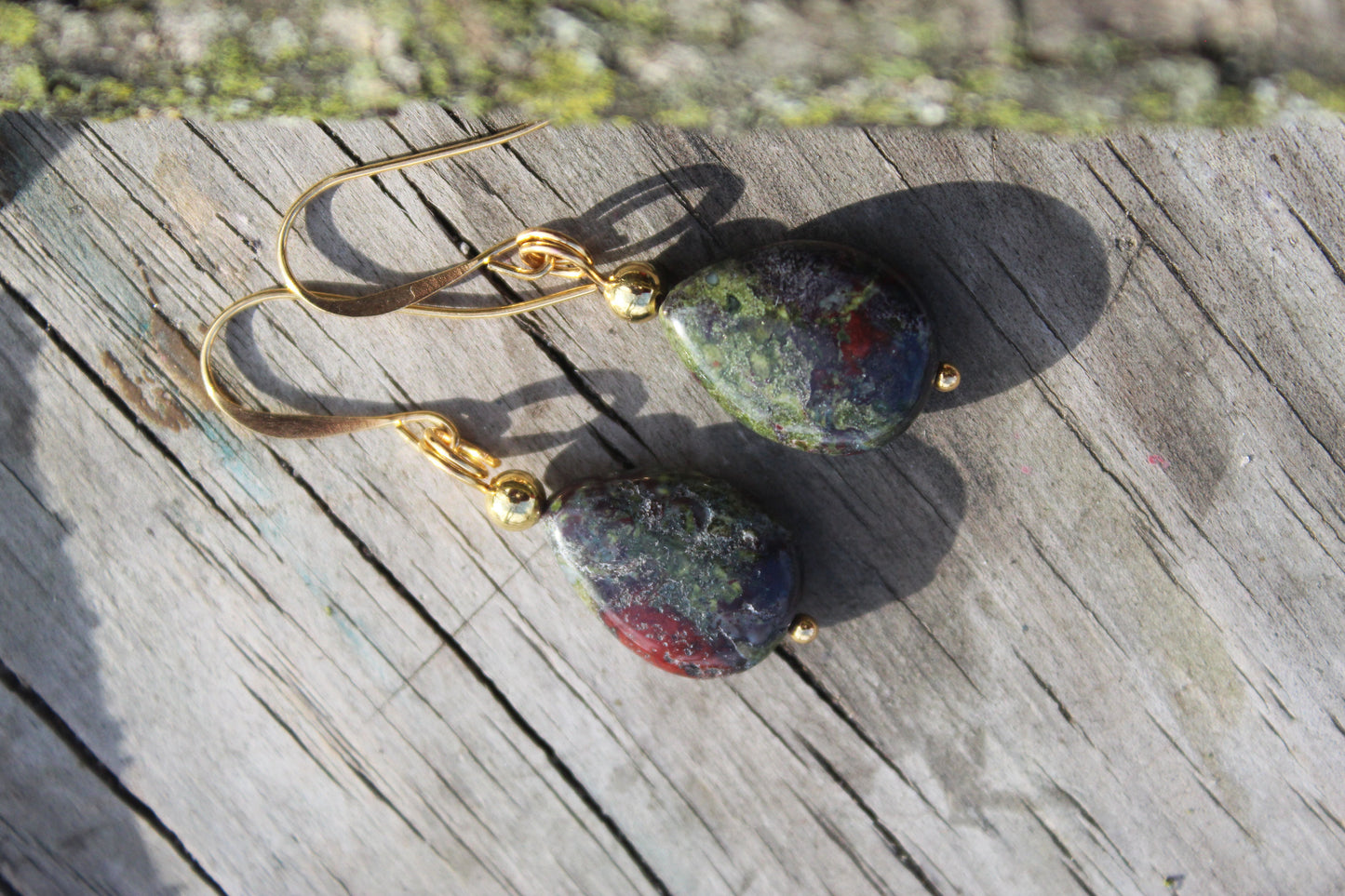 Close-up of Dragon’s Blood Jasper teardrop earrings with polished natural gemstones and gold-plated ear wires